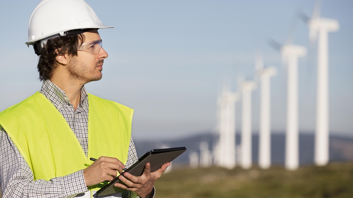 geodeta przed farmą wiatrową